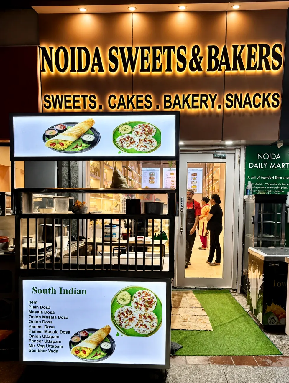 Our live South Indian counter — our photo Live South Indian counter with dosa and uttapam menu boards at Noida Sweets and Bakers, Greater Noida