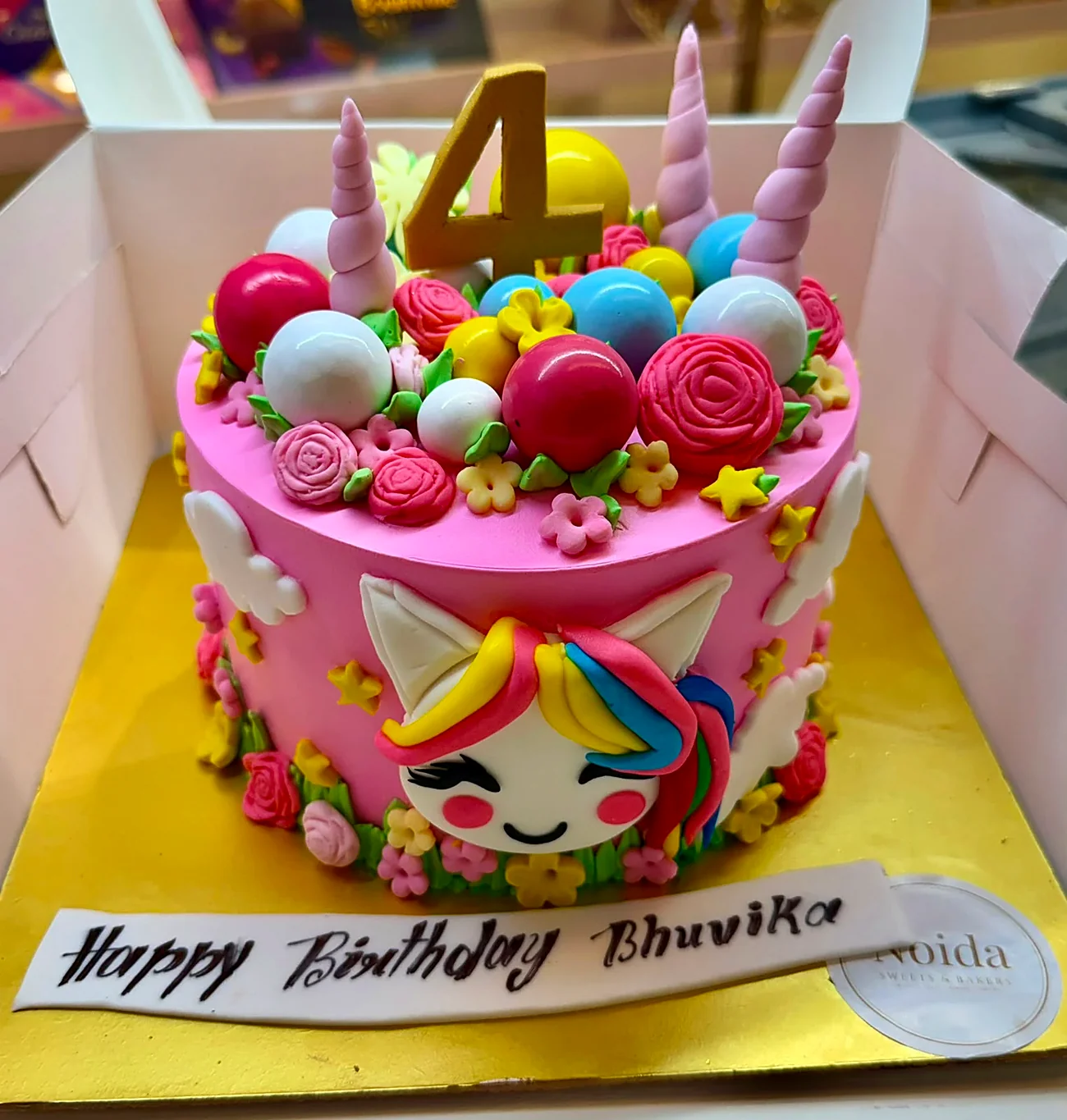 Pink unicorn theme 4th birthday cake with rainbow mane, fondant roses and candy pearls for Bhuvika — real cake by Noida Sweets and Bakers, Greater Noida